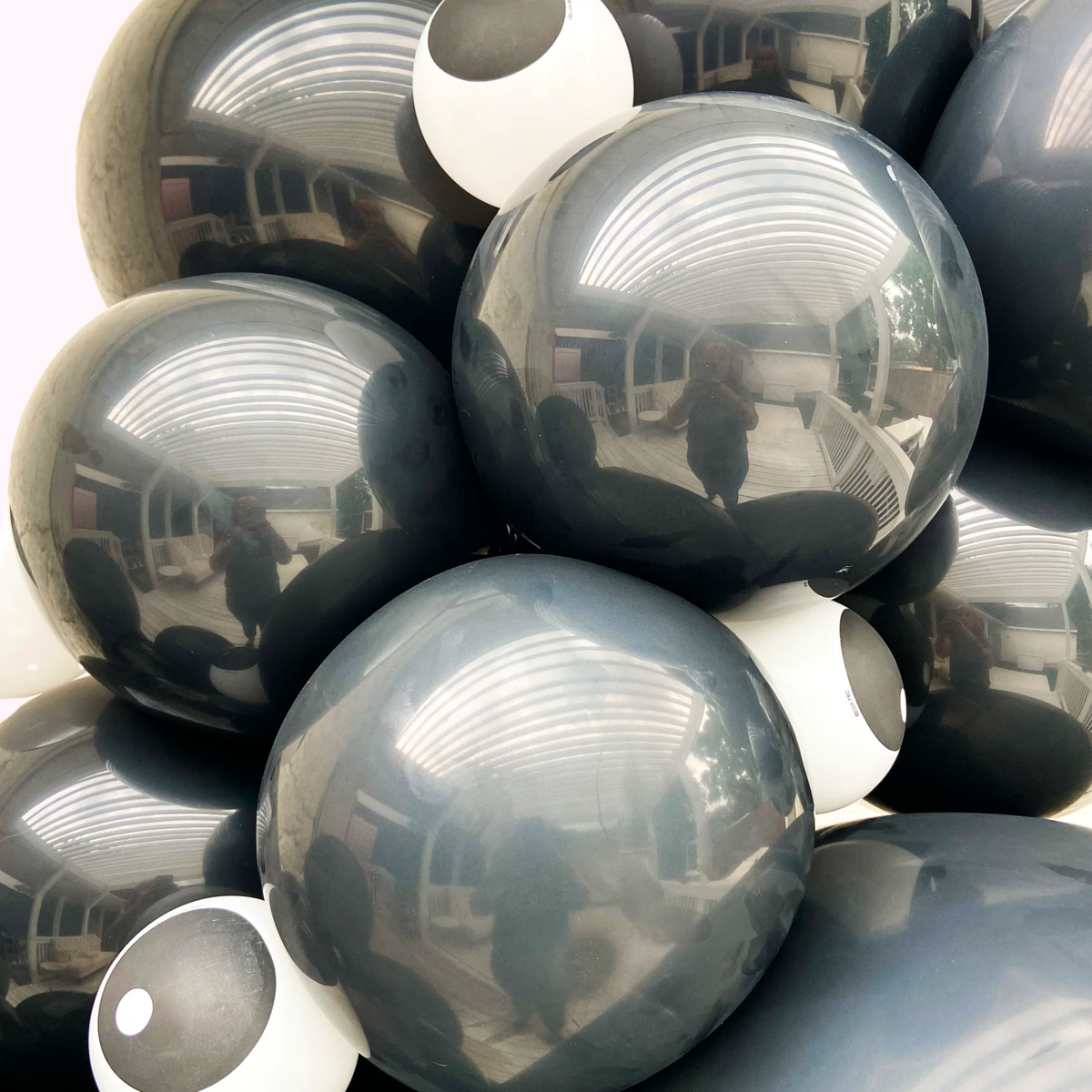 Stack of reflective metallic spheres with a blurred indoor background