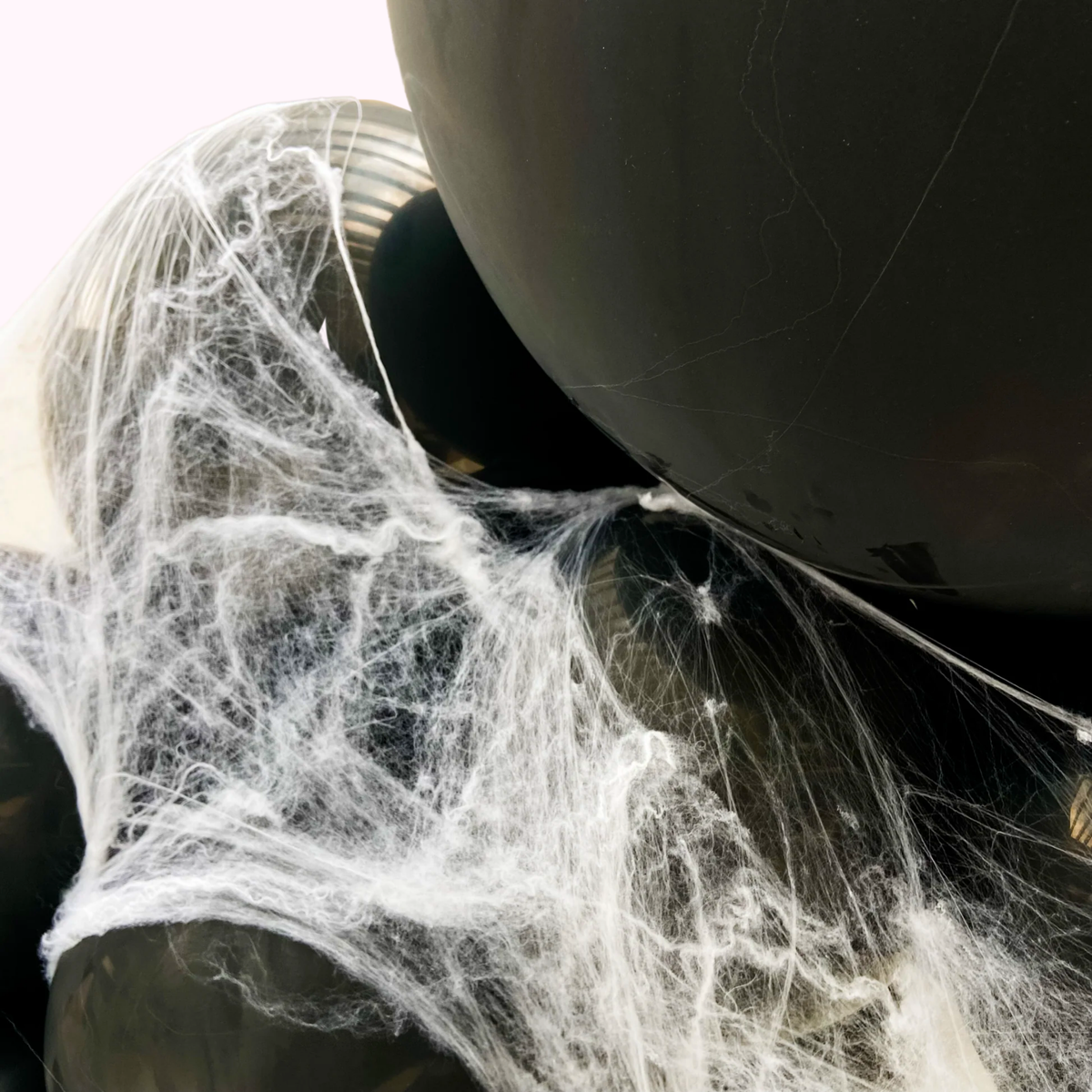 Close-up of a car exhaust with spider webs on a white background