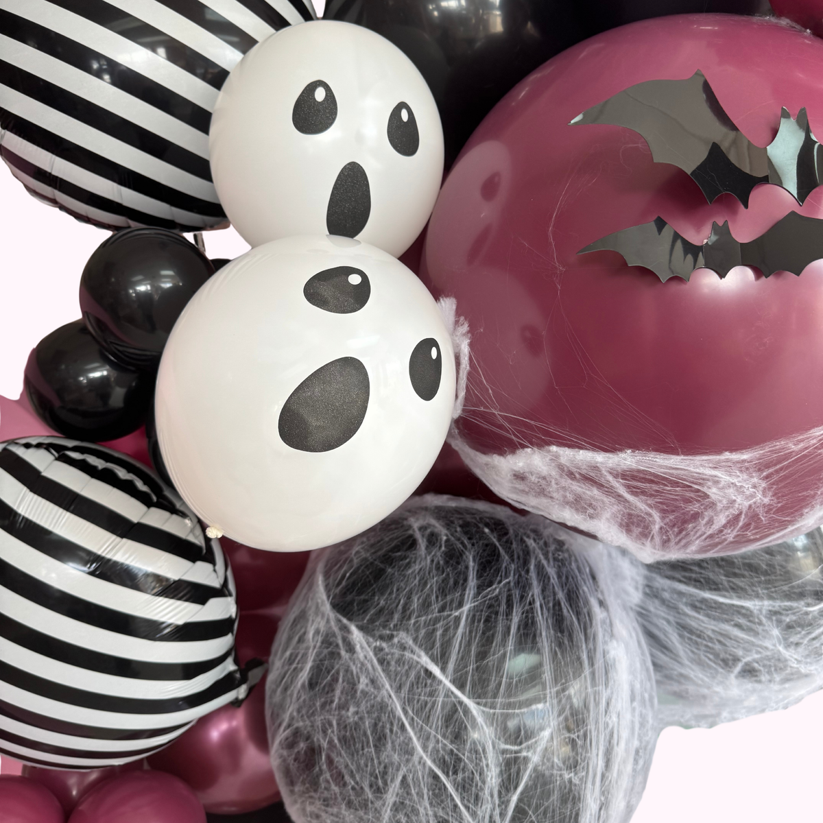 Halloween-themed balloons with ghost, bat, and spider web designs.